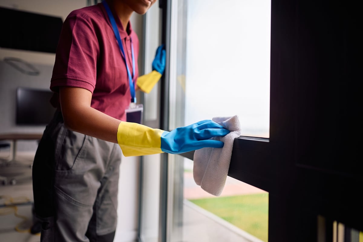 Professional cleaner polishing office glass to a flawless finish